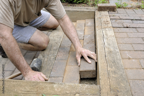 Worker Installing Brick Pavers
