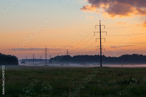 High voltage power lines, fog and sunset