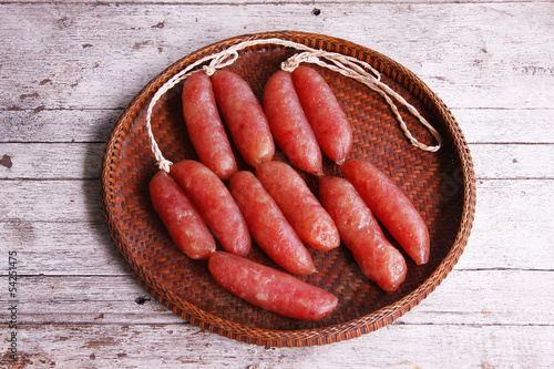Chinese sausages in the threshing basket on wooden table