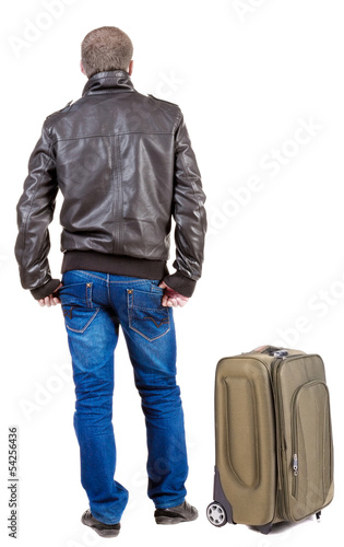 Back view of traveling man with suitcase looking up.