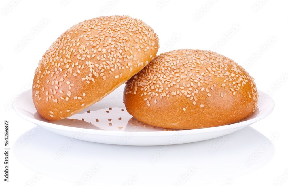 Two round sandwich bun with sesame seeds on a plate isolated Two round sandwich bun with sesame seeds on a plate isolated