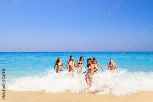 group of six girls running in the sea