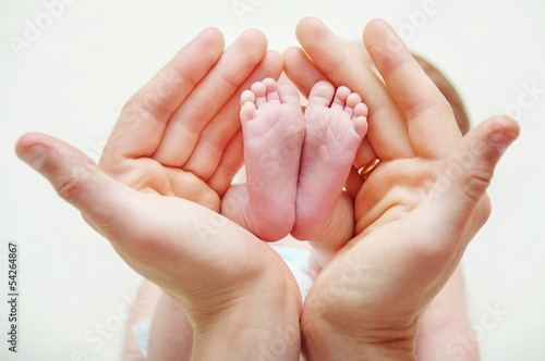 Feet of newborn baby in mothers hands