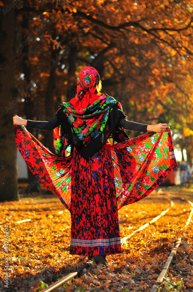 Romantic young gypsy woman pulls up dress and walks on the railr Romantic young gypsy woman pulls up dress and walks on the railr