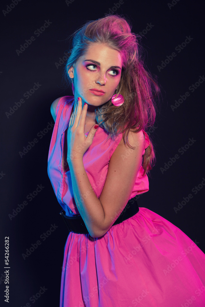 Naughty retro 80s fashion girl with pink dress and long blonde h