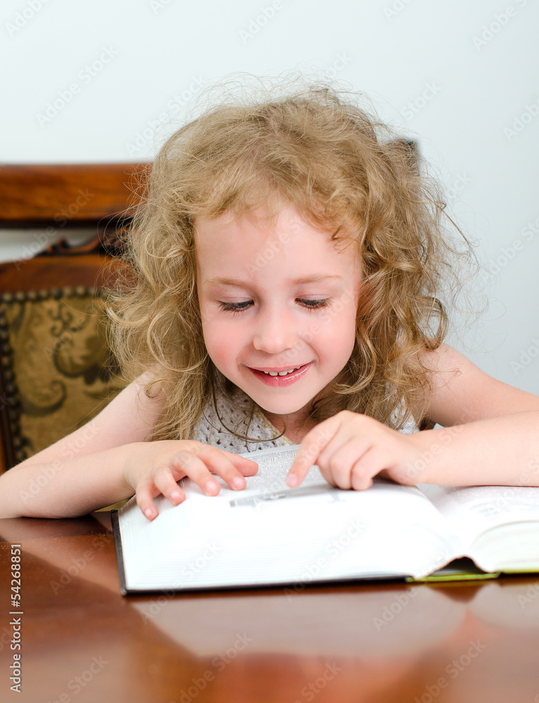 Cute little smiling girl reading a book Cute little smiling girl reading a book