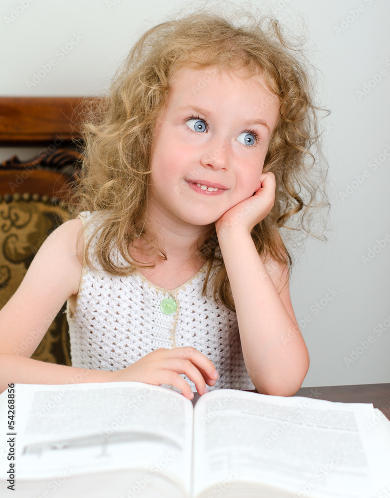 Cute little smiling girl reading a book Cute little smiling girl reading a book