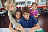 Cute Schoolchildren Using Laptop At Desk