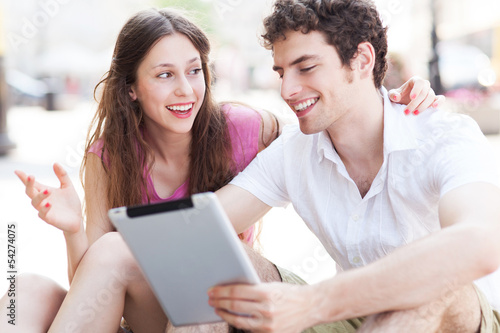Young couple using digital tablet outdoors
