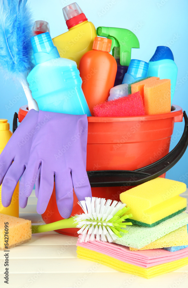 Cleaning items in bucket on color background Cleaning items in bucket on color background
