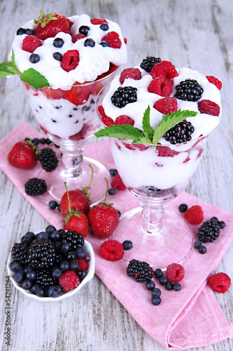 Natural yogurt with fresh berries on wooden background