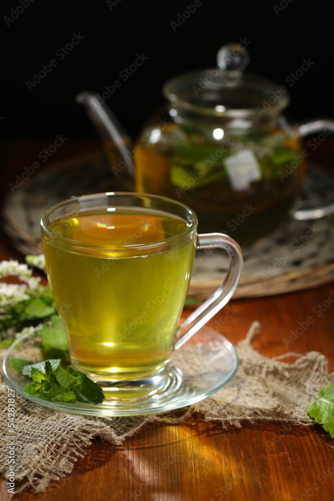 Cup and teapot of herbal tea with fresh mint flowers Cup and teapot of herbal tea with fresh mint flowers