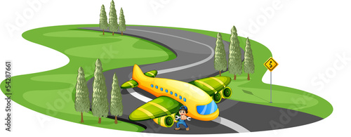 A boy with a plane landing at the long winding road