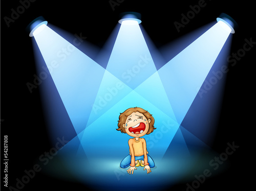 A girl crying in the middle of the stage with spotlights