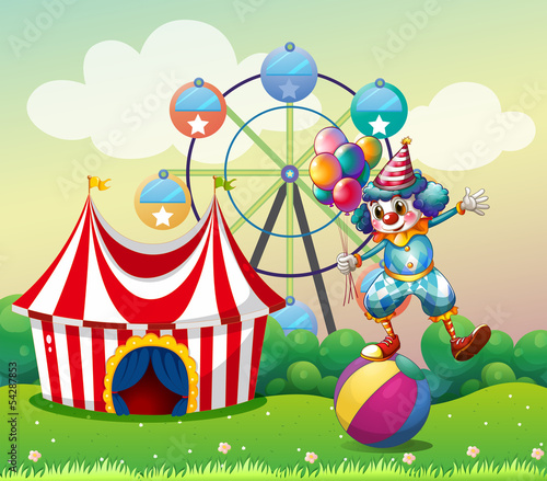 A clown balancing above an inflatable ball at the carnival