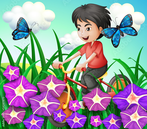 A boy biking in the garden with flowers and butterflies