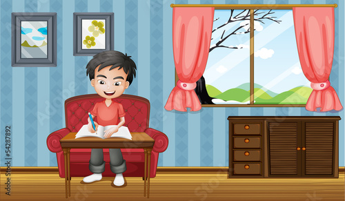 A boy writing inside the house