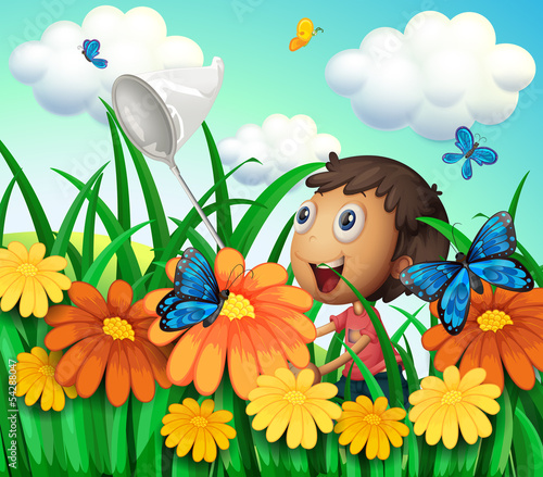 A boy catching butterflies at the flower garden