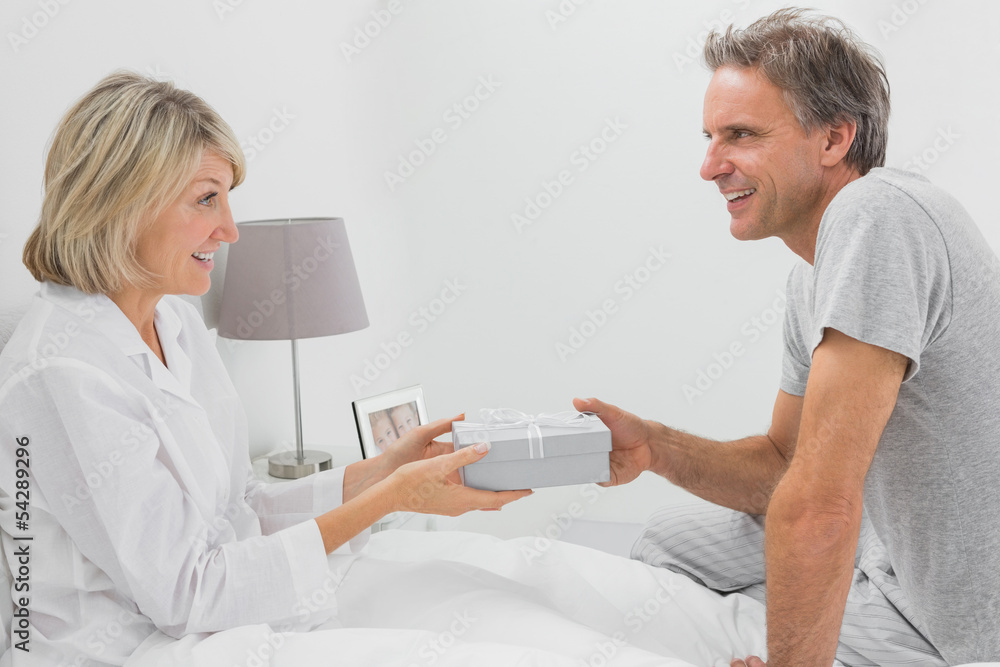 Fototapeta premium Man giving present to his smiling partner