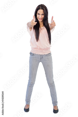 Smiling brunette does thumbs up at camera