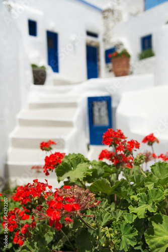 white - blue Santorini traditional architecture with flowers