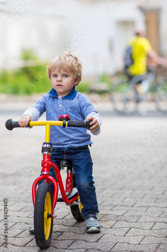 2 years old toddler riding on his first bike
