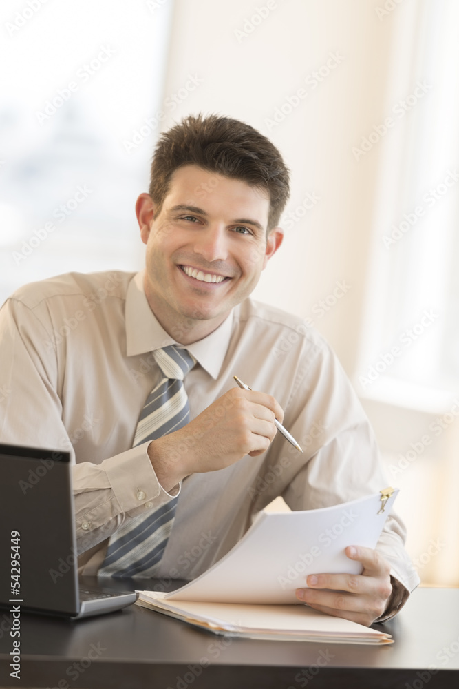 Businessman With Documents And Pen Sitting At Desk Businessman With Documents And Pen Sitting At Desk