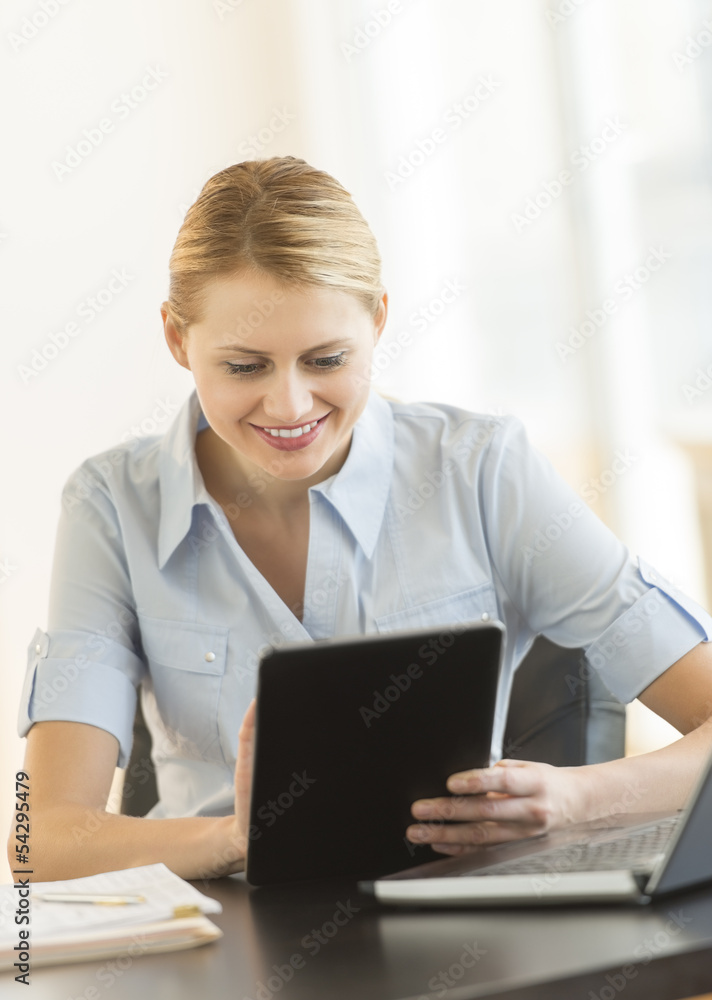 Happy Businesswoman Using Digital Tablet At Desk Happy Businesswoman Using Digital Tablet At Desk