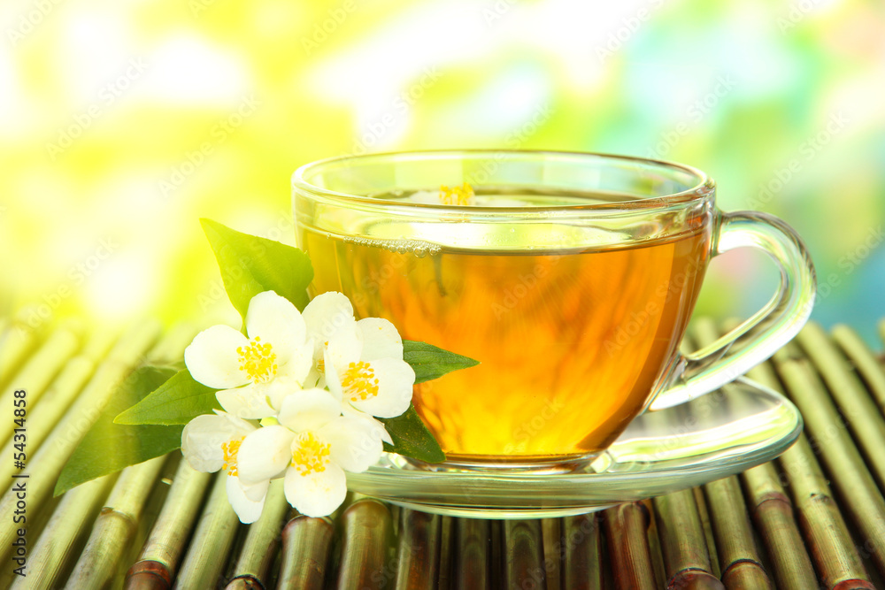 Cup of tea with jasmine, on bamboo mat, close-up Cup of tea with jasmine, on bamboo mat, close-up
