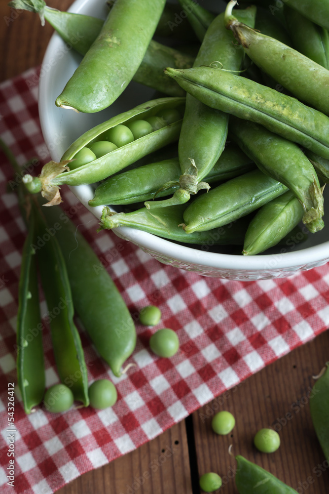 Pea pods in a bowl on wooden Table Pea pods in a bowl on wooden Table