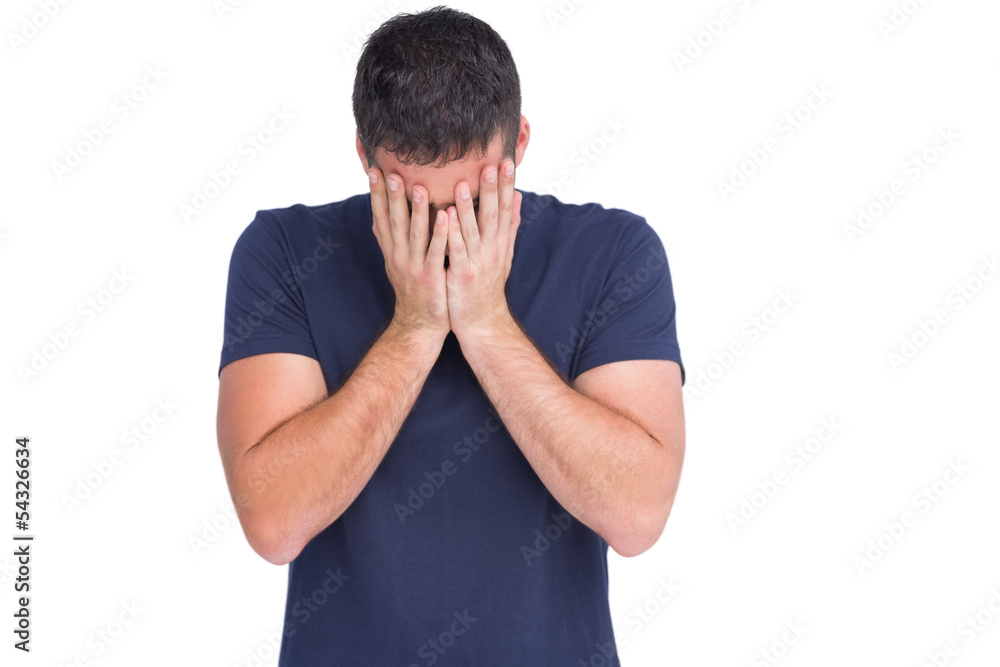Upset man standing with his head between hands Upset man standing with his head between hands