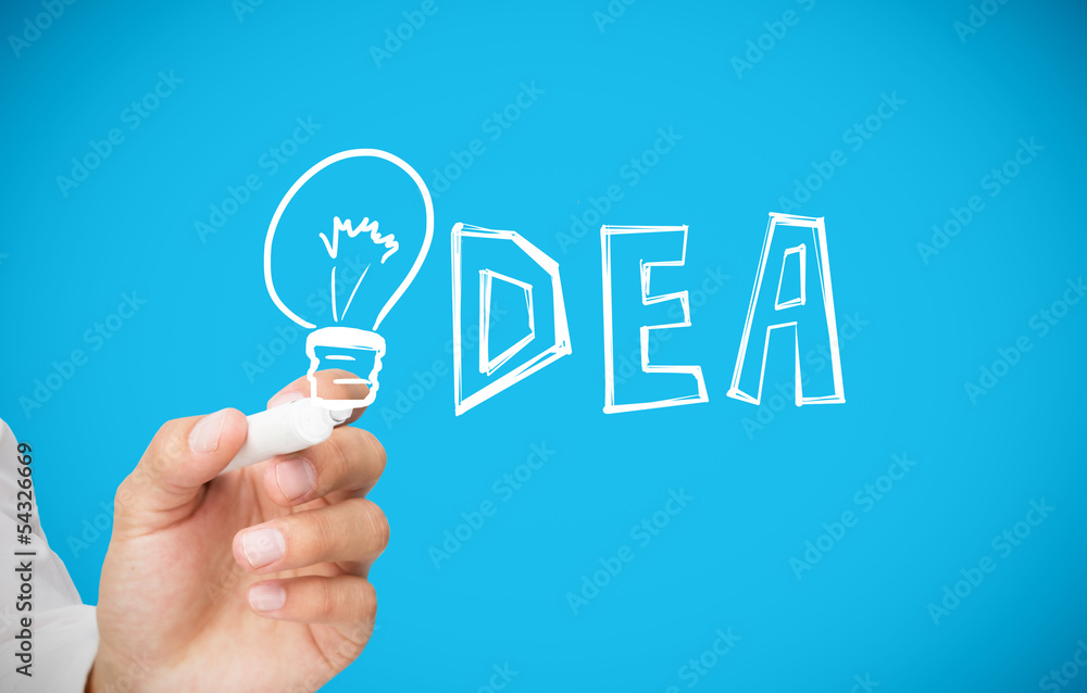 Businessman drawing light bulb as the i in idea Businessman drawing light bulb as the i in idea
