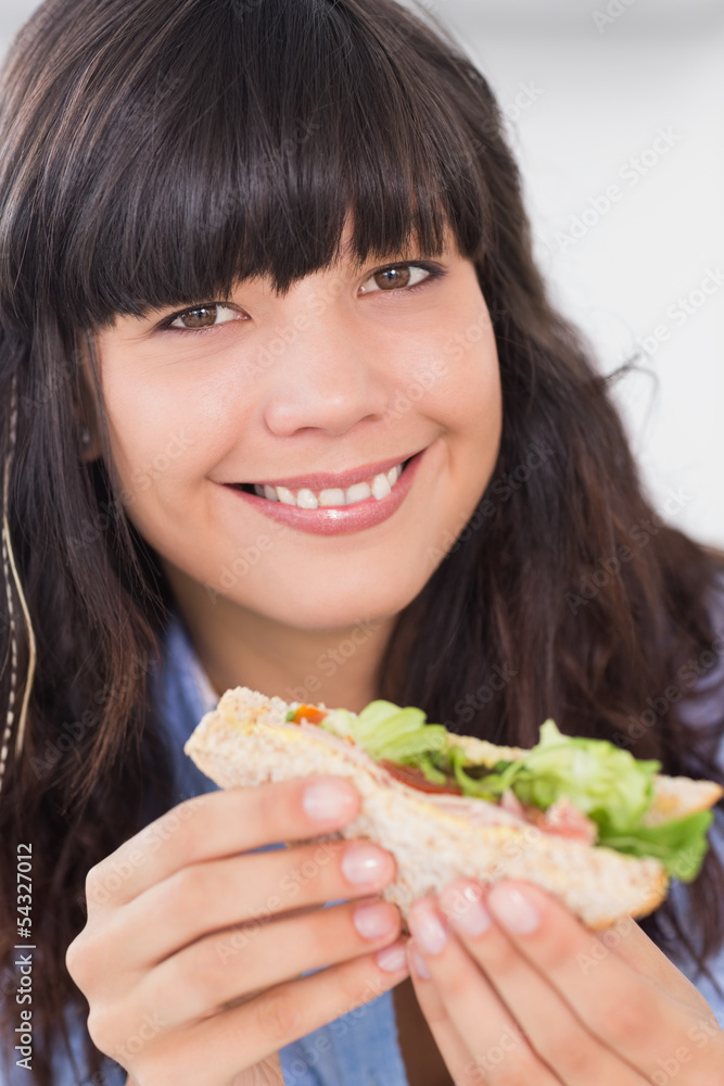 Cheerful brunette having a salad sandwich Cheerful brunette having a salad sandwich