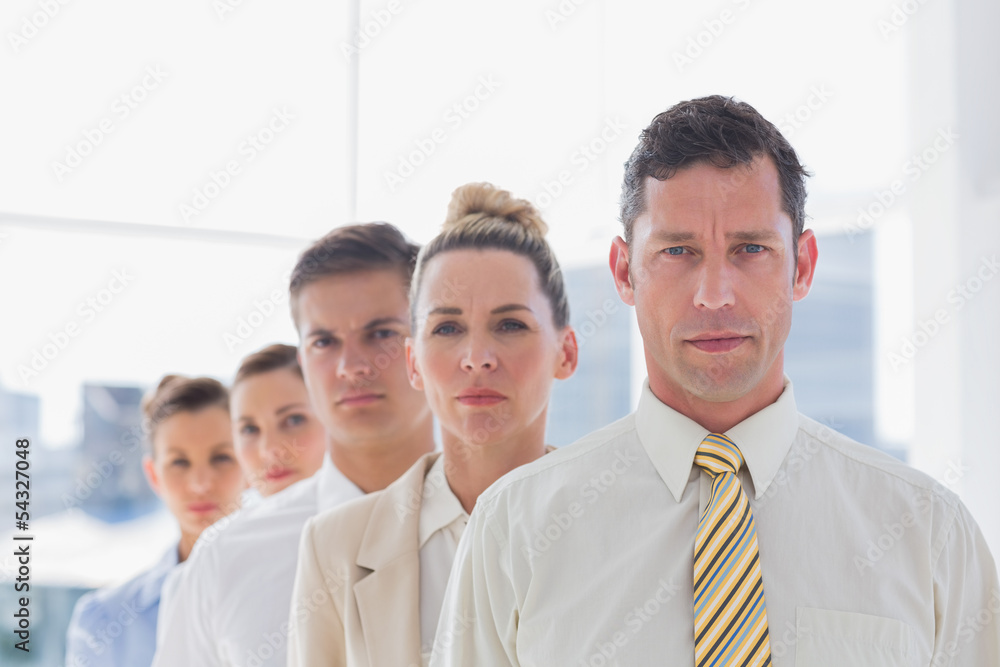 Serious handsome businessman standing with team Serious handsome businessman standing with team