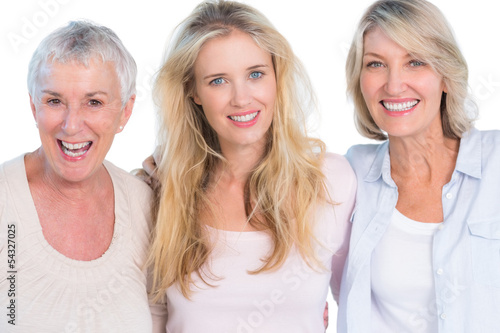 Three generations of cheerful women smiling at camera