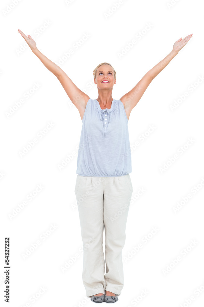 Blonde woman standing with hands up in air Blonde woman standing with hands up in air