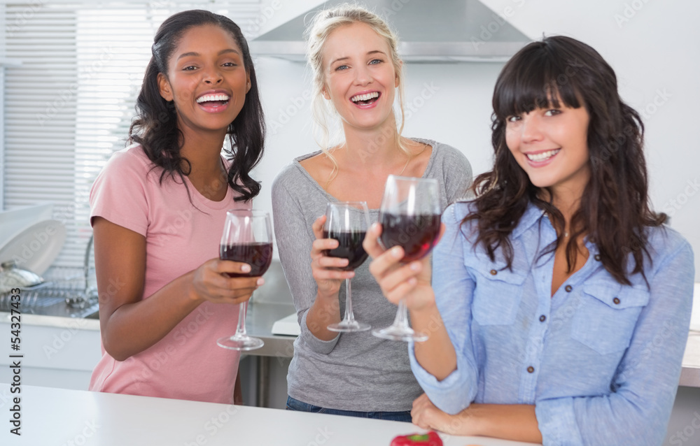 Cheerful friends enjoying glasses of red wine Cheerful friends enjoying glasses of red wine