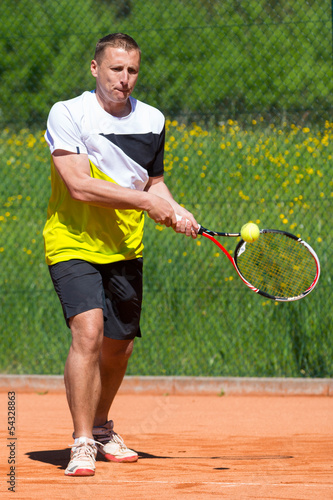 tennis backhand with ball on racket on sand court © A2LE
