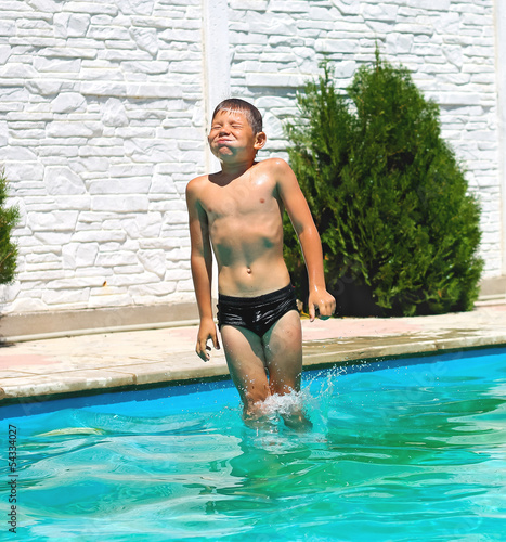 Funny boy are jumping to the swimming pool