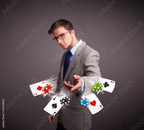 Young man playing with poker cards and chips
