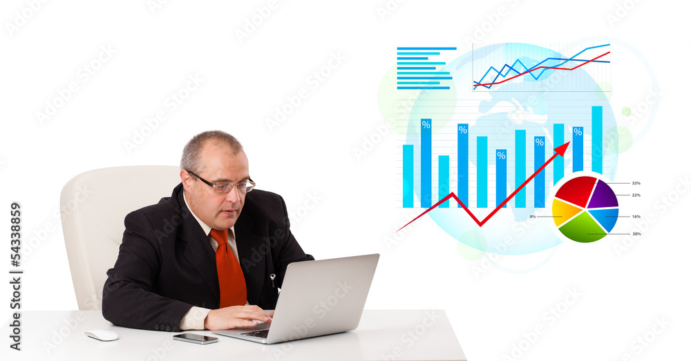 Businessman sitting at desk with laptop and statistics Businessman sitting at desk with laptop and statistics