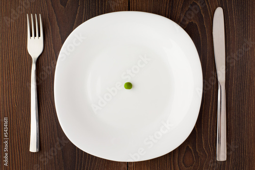 One pea on a white plate