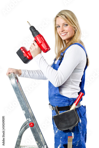 young woman with a drill on a ladder photo