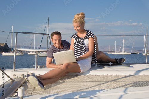 Junges Paar surft im Internet und schreibt e-mails am Segelboot © Jeanette Dietl