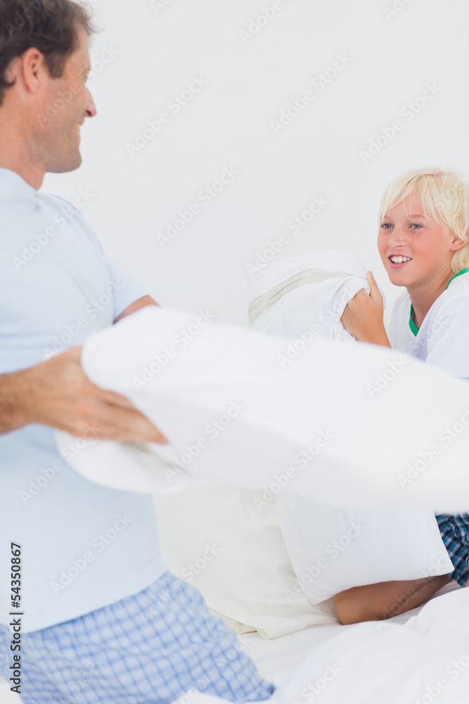 Fototapeta premium Pillow fight between and father and his son