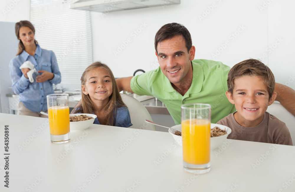 Portrait of a father and his children having breakfast Portrait of a father and his children having breakfast