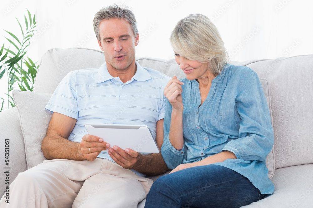 Couple using tablet together on the couch