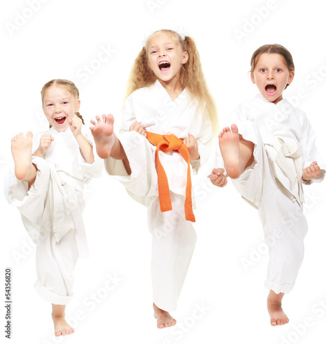 Three girls dressed in white kimono perform punch