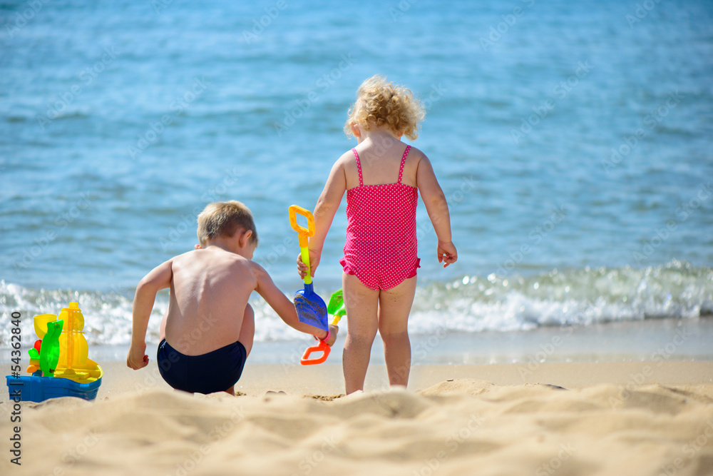 Little brother and sister playing with sand Little brother and sister playing with sand