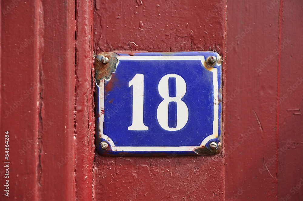 House Number Eighteen sign on red wooden panel House Number Eighteen sign on red wooden panel